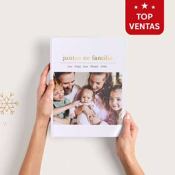 Un álbum de fotos CEWE abierto con momentos familiares felices.