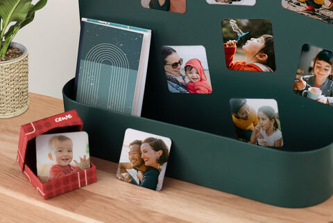 Un álbum de fotos cuidadosamente diseñado y recuerdos sobre una mesa, rodeado de fotos y una planta.