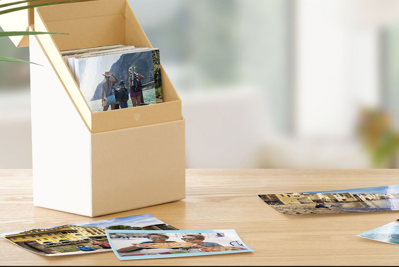 Una caja decorativa con fotos y algunas imágenes que están en una mesa en primer plano.