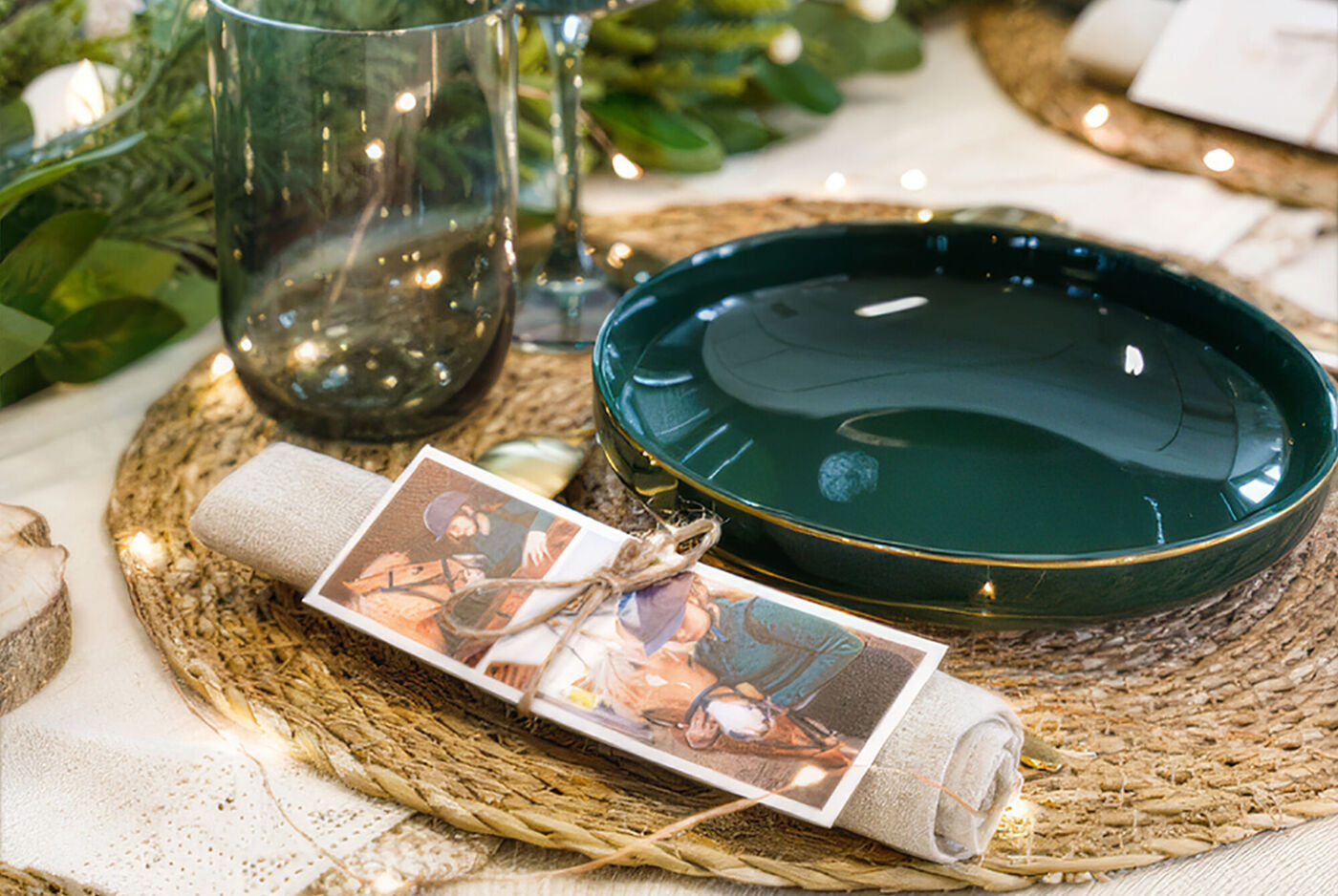 Mesa navideña elegante con foto personalizada decorando la servilleta junto a vajilla verde.