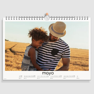 Padre con hijo en un campo, hoja del calendario muestra un momento soleado.