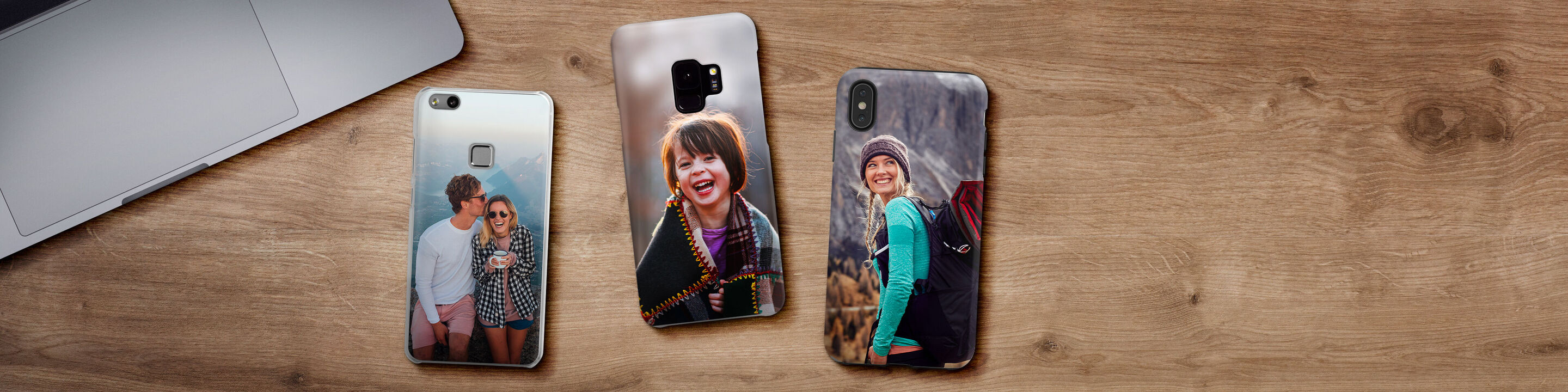 Tres fundas de teléfono individuales con fotos de amigos sobre una mesa de madera.