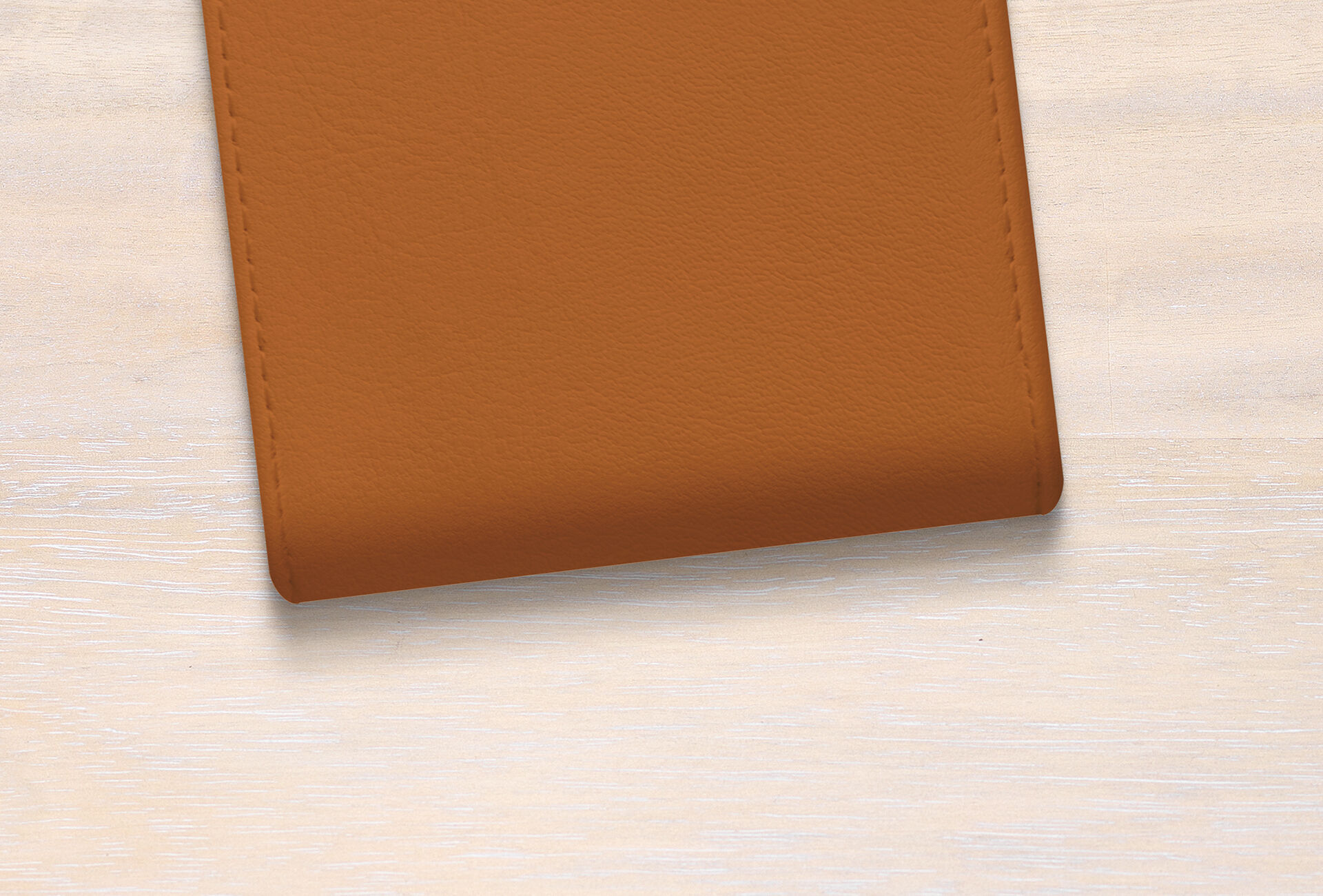 Funda de cuero marrón sobre una mesa de madera clara.