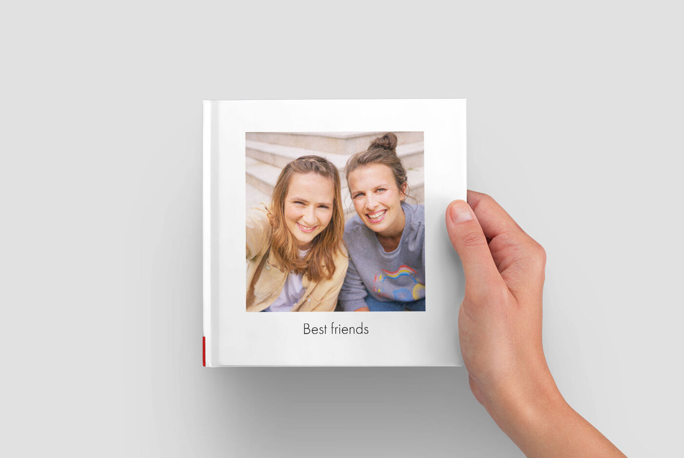 Joven sostiene un álbum CEWE titulado 'Mejores amigos'.