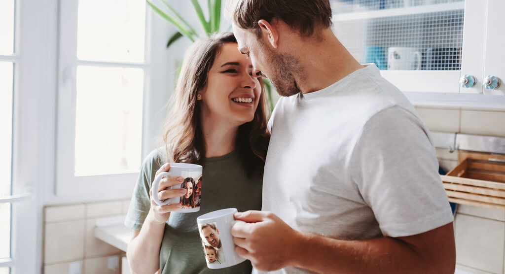 Una pareja disfruta de un momento juntos en la cocina con tazas en las manos