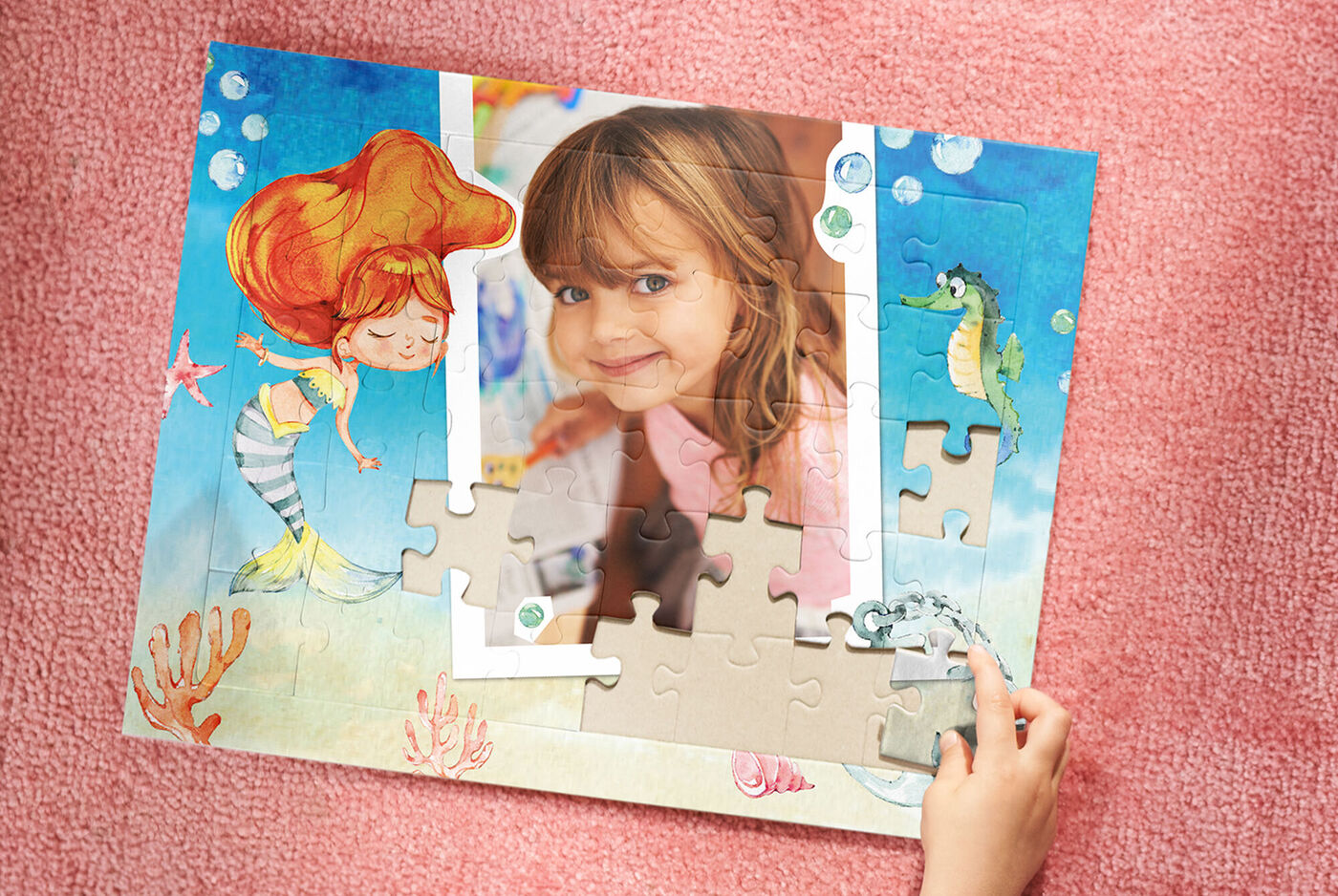Un niño arma un rompecabezas sobre una base colorida, el rompecabezas muestra una sirena y otros elementos marinos.