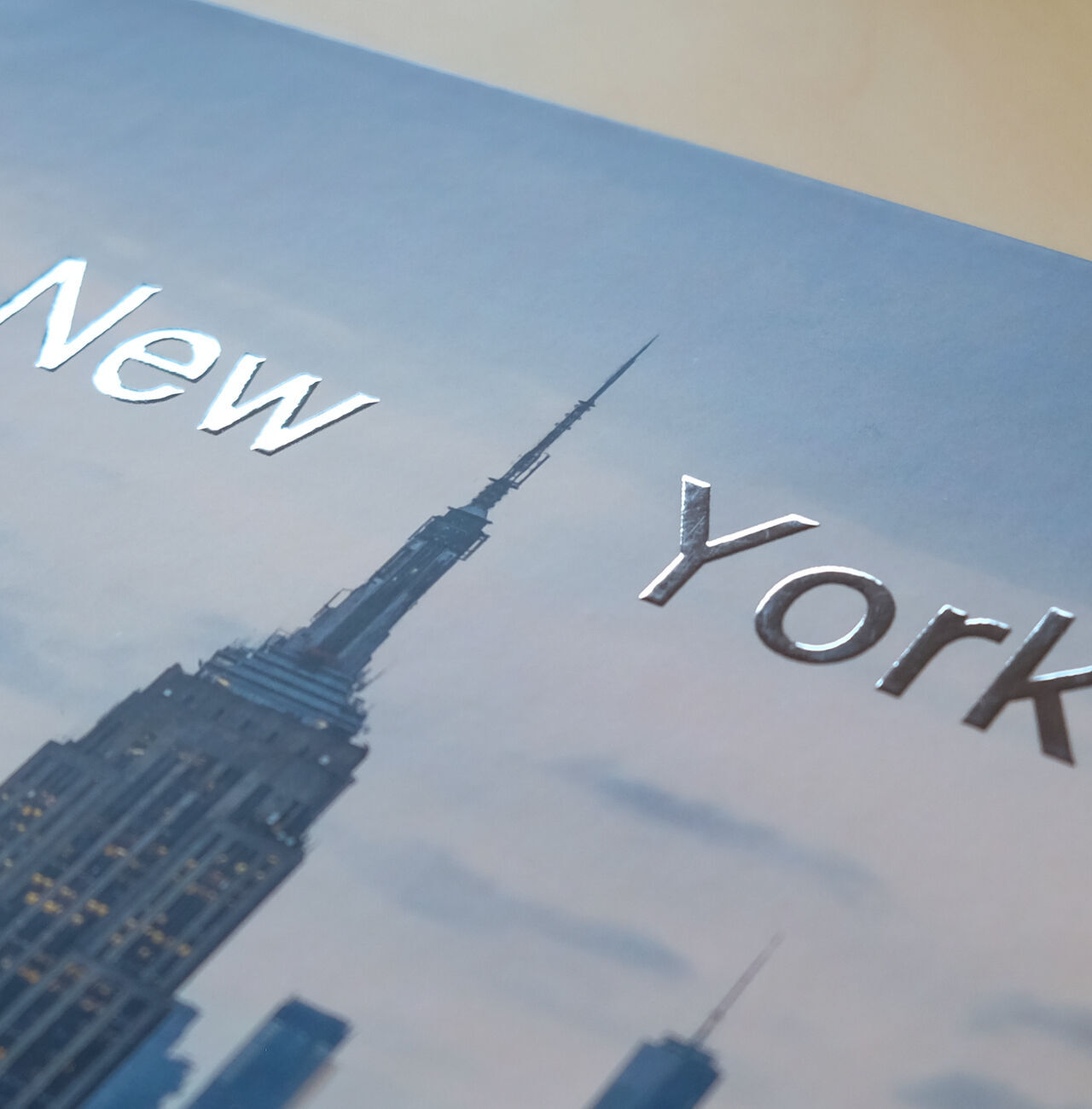 Acercamiento a la portada de un foto libro con 'Nueva York' y el Empire State Building.