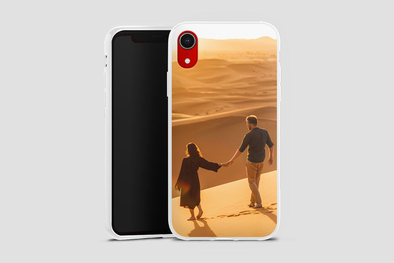 Una pareja se toma de la mano por detrás en la playa, caminando sobre la arena, iluminada por la luz cálida del sol