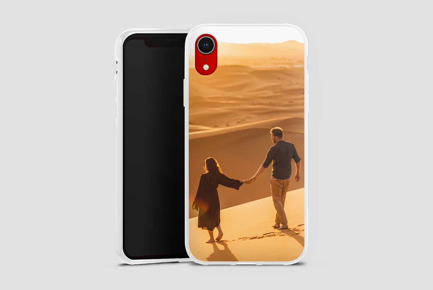 Una pareja se toma de la mano por detrás en la playa, caminando sobre la arena, iluminada por la luz cálida del sol