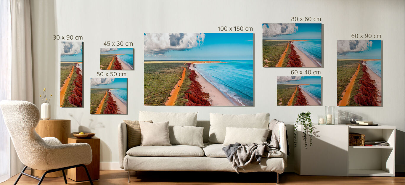 Diferentes tipos de formatos de lienzo fotográficos expuestos en la pared de un salon con un sofa y un mueble.