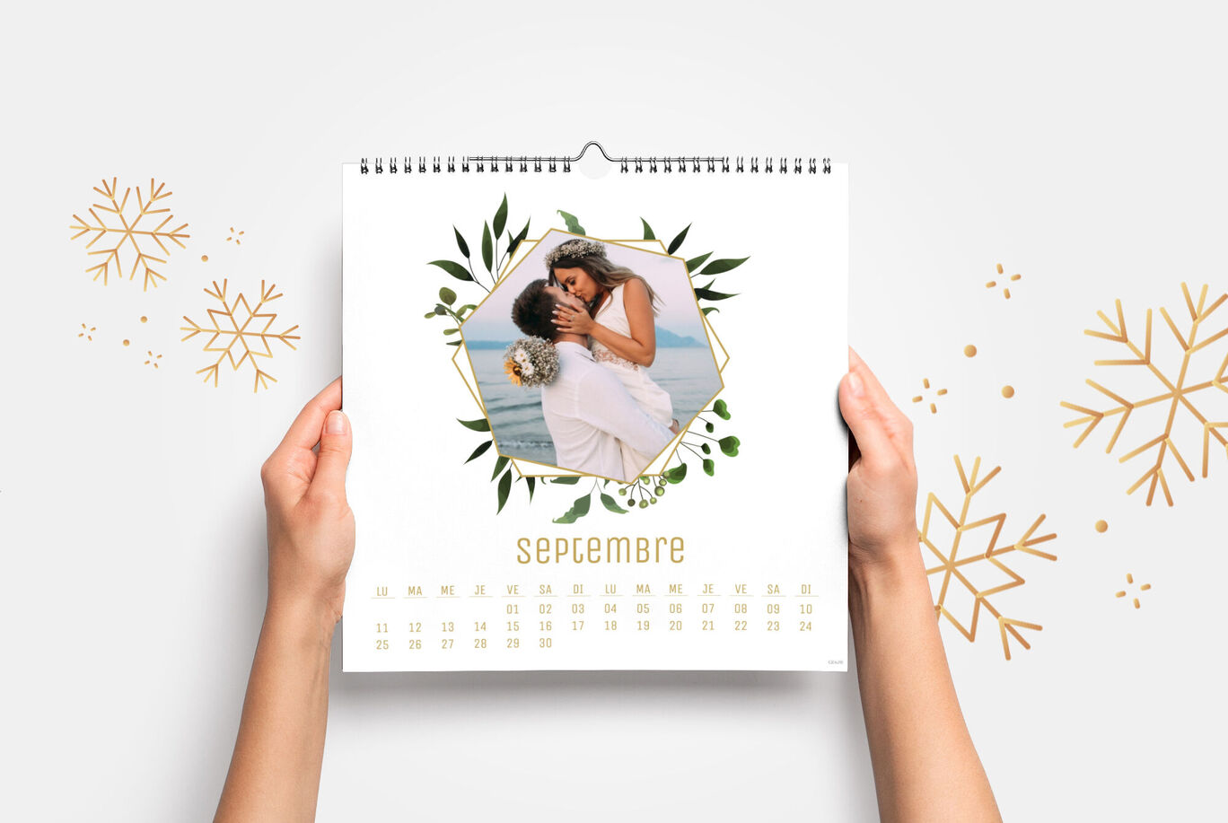 Una persona sostiene un calendario con una foto de una pareja enamorada. El mes de septiembre está destacado.