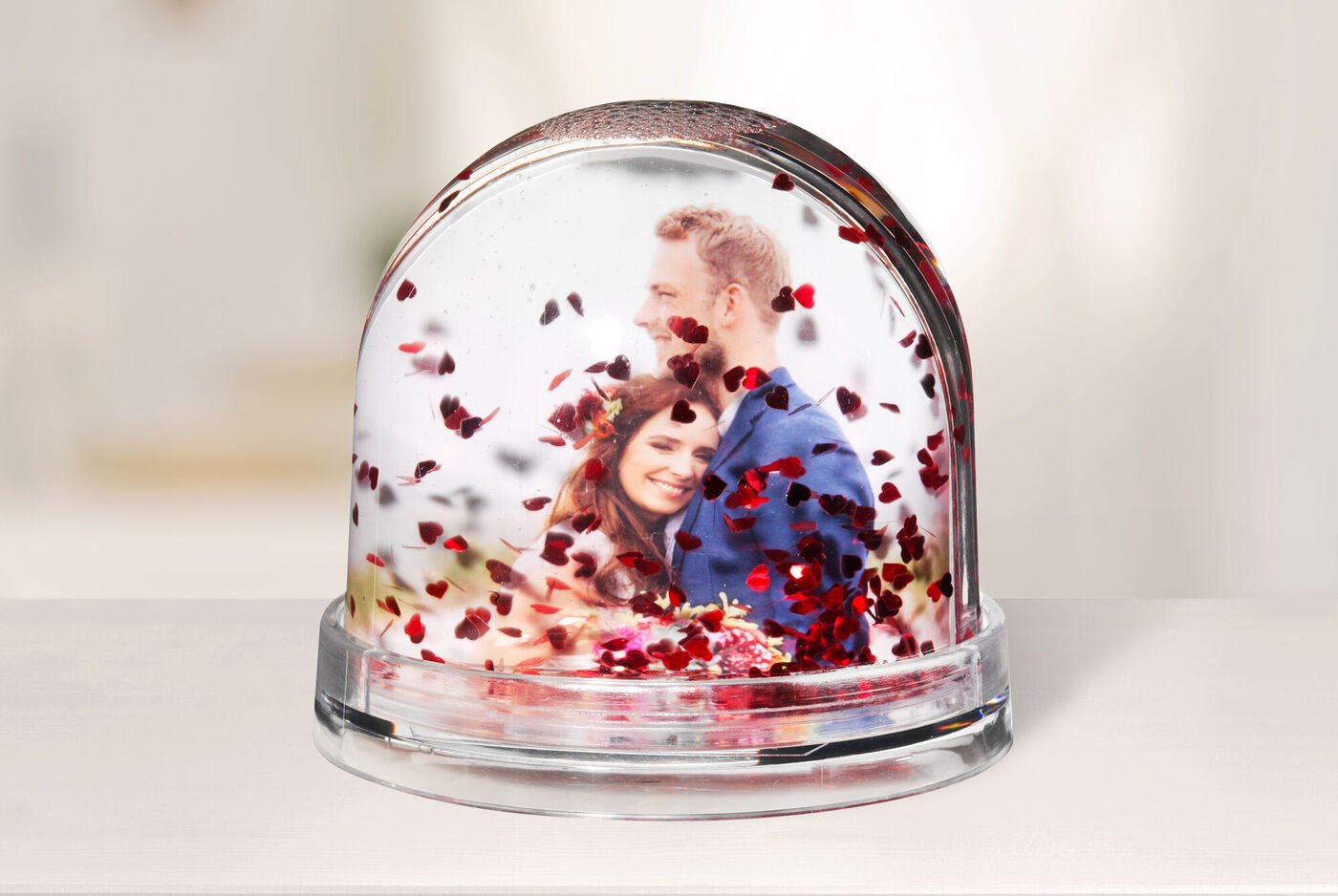 Una tierna bola de nieve con confeti en forma de corazón, que muestra una escena romántica.