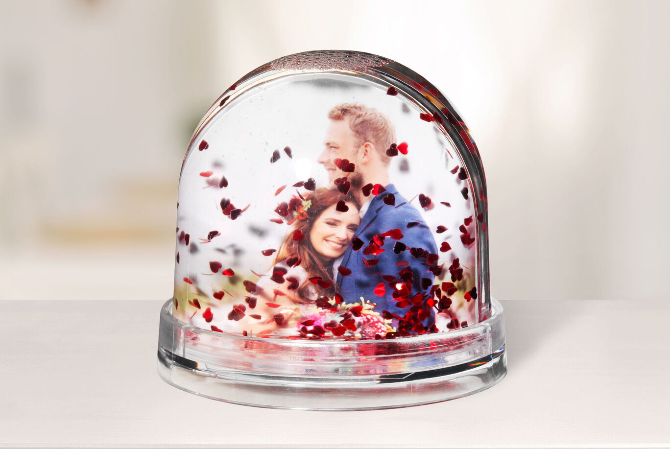 Una tierna bola de nieve con confeti en forma de corazón, que muestra una escena romántica.