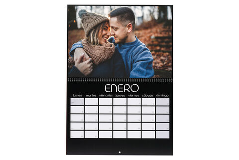 Una pareja se abraza en un hermoso bosque en enero. El calendario CEWE muestra el mes.