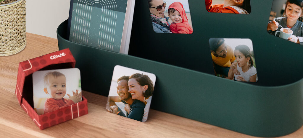 Varias tarjetas fotográficas y un producto CEWE en un almacenamiento moderno, que transmite alegría al compartir recuerdos