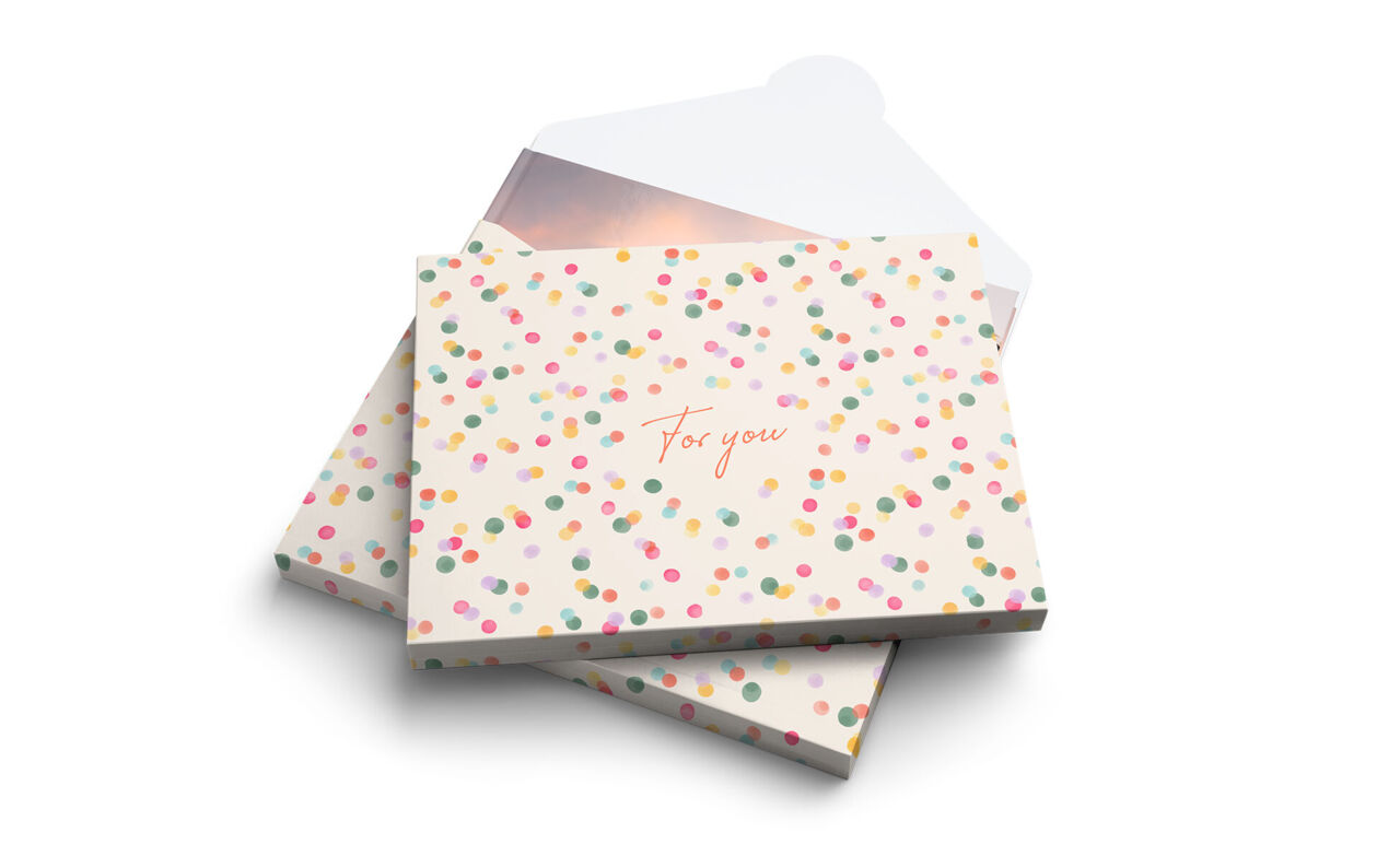 Envoltorio de regalo para álbum de fotos con estampado de confeti multicolor y el texto «For you» en el centro.