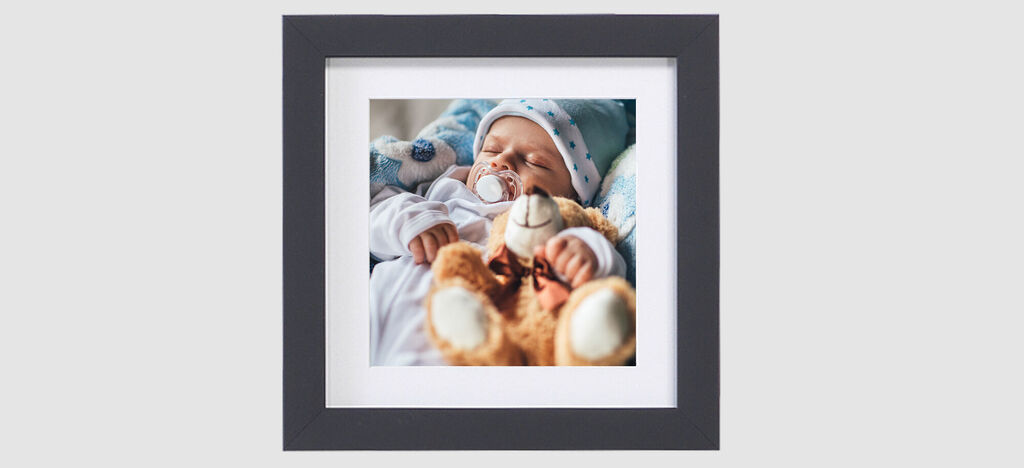 Un dulce bebé sostiene un peluche en sus manos.