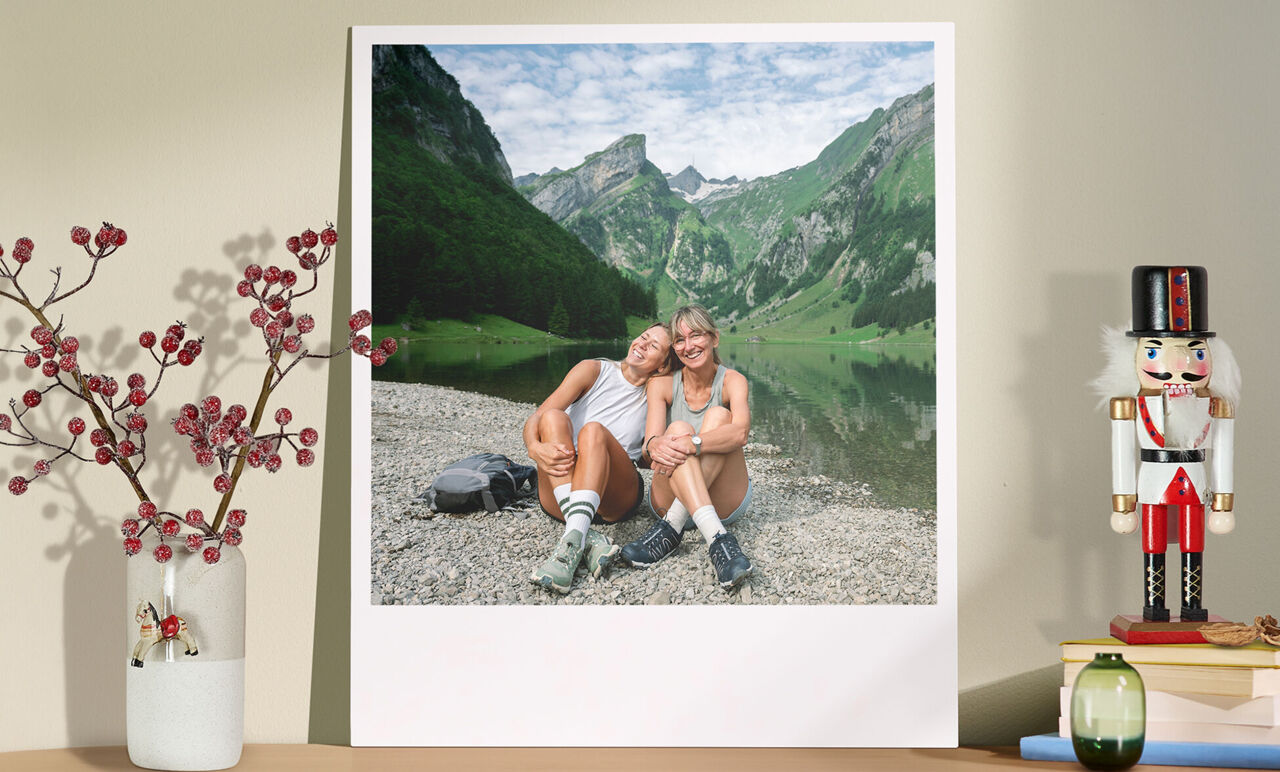 Foto estilo Retro XXL de dos personas sentadas junto a un lago de montaña, con un jarrón de flores secas y un cascanueces