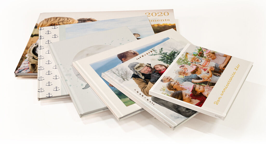 Varios CEWE fotolibros en diferentes diseños y tonalidades.