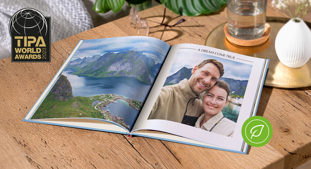 Un álbum abierto muestra una hermosa vista de montañas y agua, un dulce recuerdo de vacaciones.
