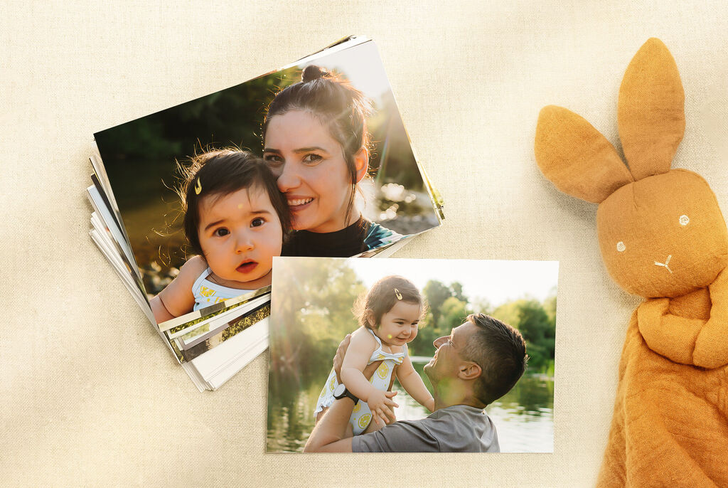 Recuerdos felices de un padre con su hijo en el agua, rodeados de montones de fotos y un conejo de peluche.
