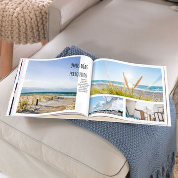 Un álbum CEWE abierto sobre una mesa, con fotos de un día de playa y momentos relajantes.