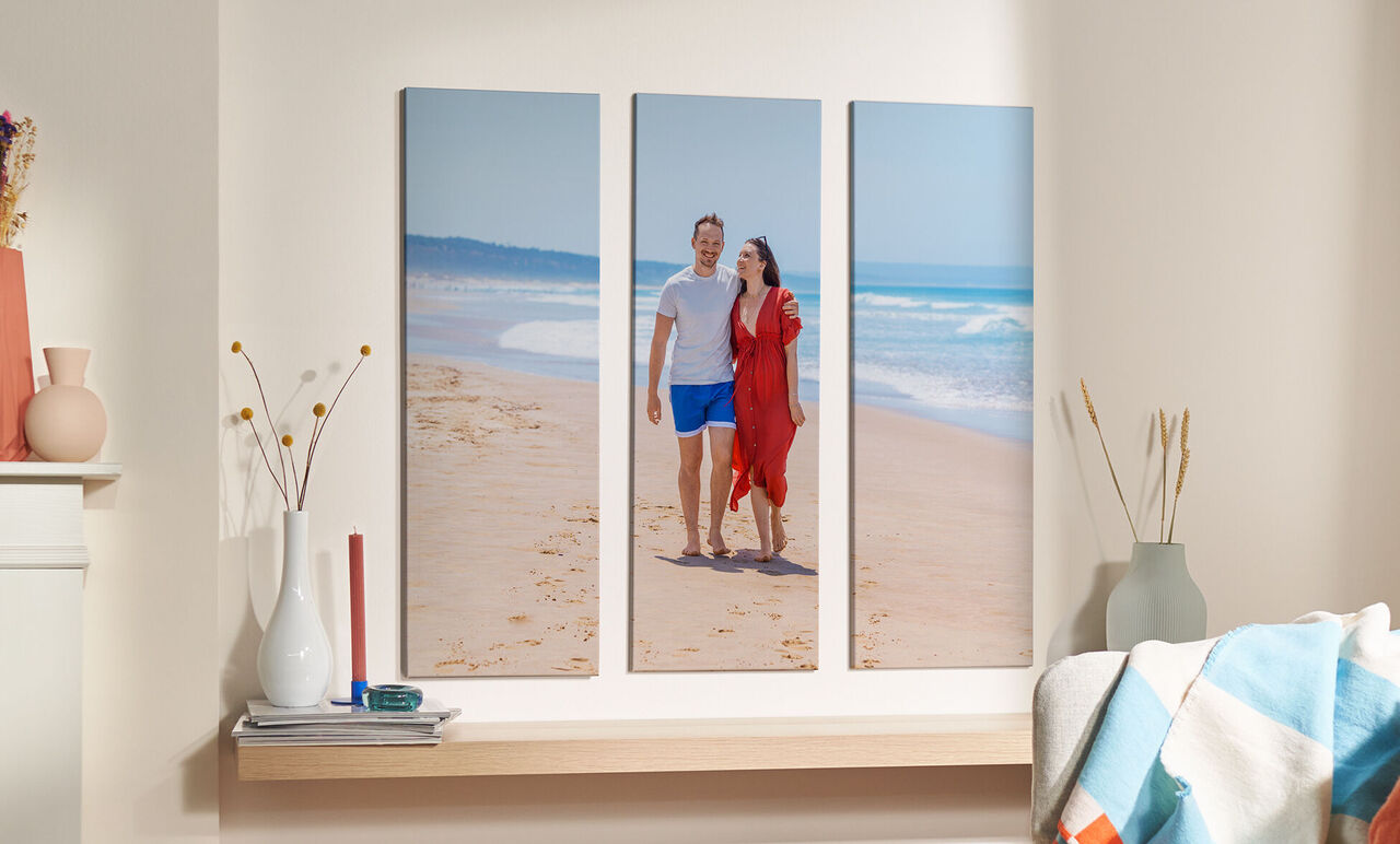 Pareja caminando en la playa con vestido rojo y camiseta blanca
