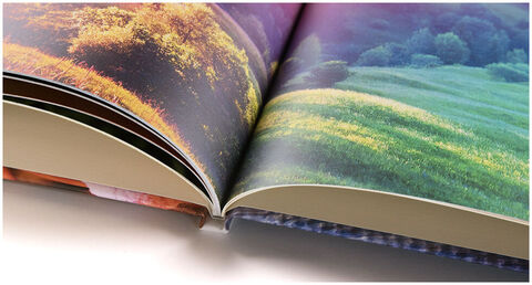 Álbum CEWE abierto con imágenes de paisajes coloridos.