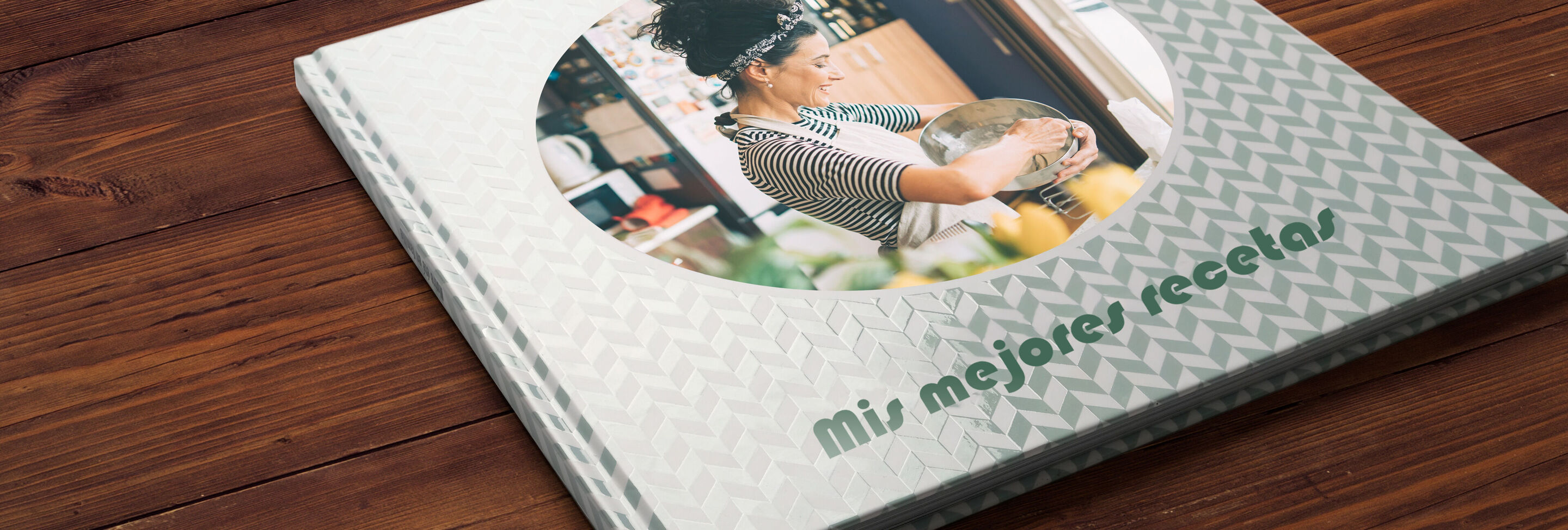 Un fotolibro abierto titulado 'Mis mejores recetas' en una mesa, rodeado de ingredientes frescos.