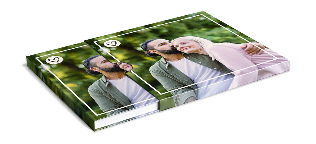 Dos CEWE fotolibros con fotos románticas, sobre un fondo verde