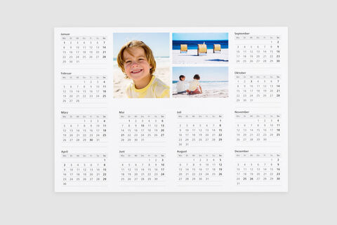 Un hermoso calendario fotográfico con imágenes de momentos en la playa y dos niños jugando.
