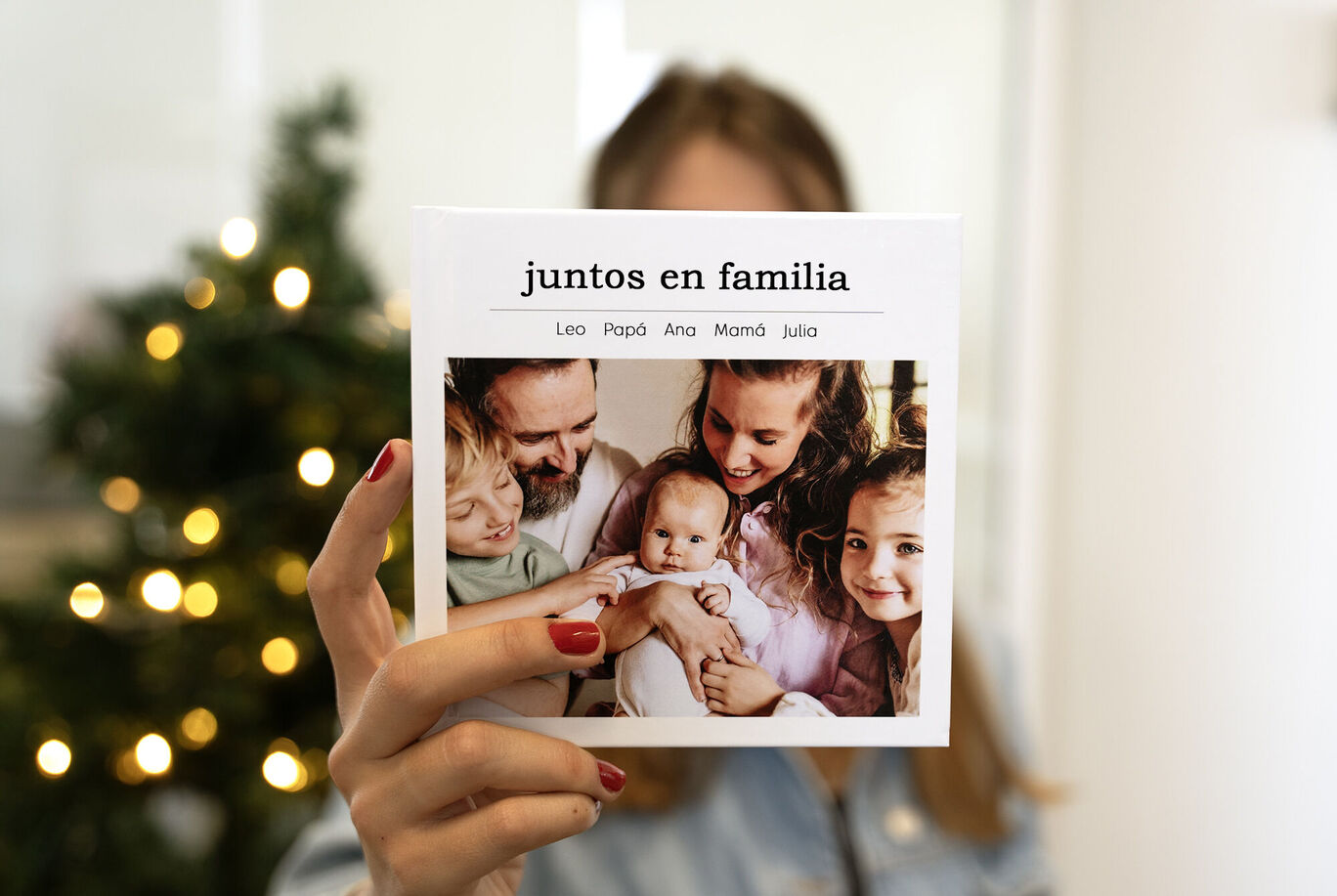 álbum de fotos CEWE navideño con una foto familiar y un árbol de Navidad de fondo. Un regalo navideño original lleno de emociones.
