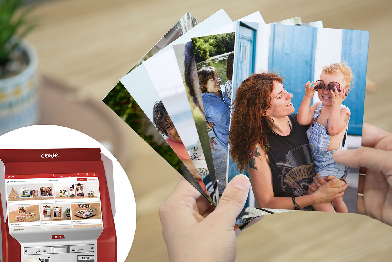 Persona sostiene una selección de fotos CEWE en la mano, impresora de fotos al fondo.