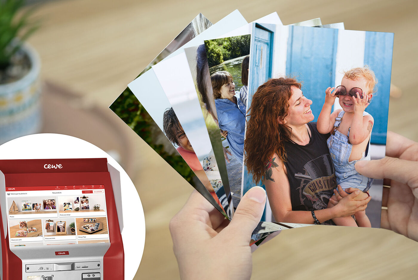 Persona sostiene una selección de fotos CEWE en la mano, impresora de fotos al fondo.