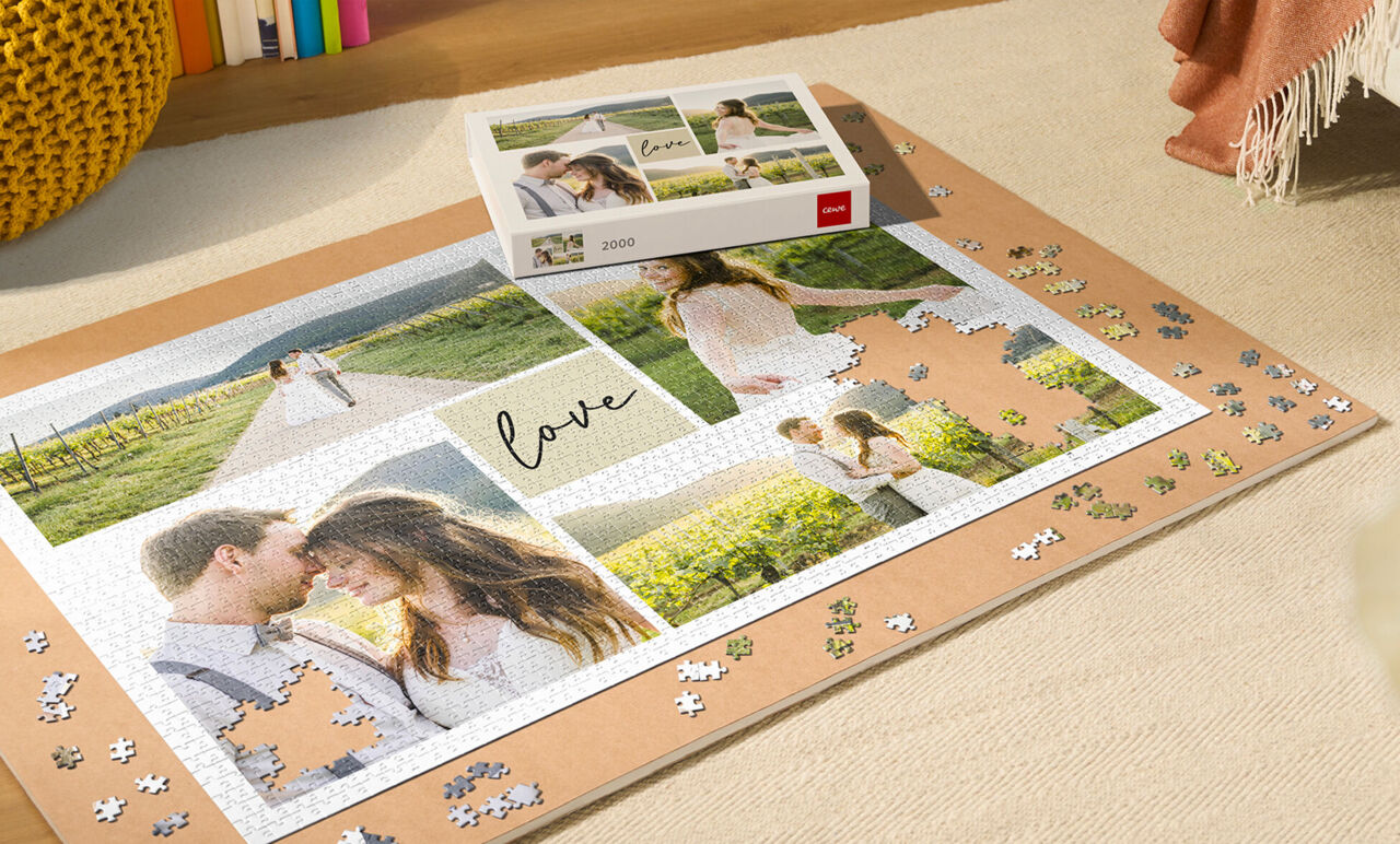 Puzzle personalizado de boda en proceso de armado sobre tapete protector para puzzles, con piezas dispersas y caja de regalo incluida.