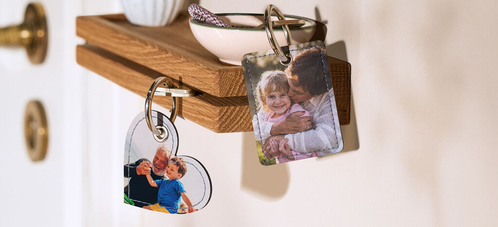 Dos llaveros con fotos que muestran recuerdos. Un llavero tiene una foto familiar y el otro muestra un abrazo.