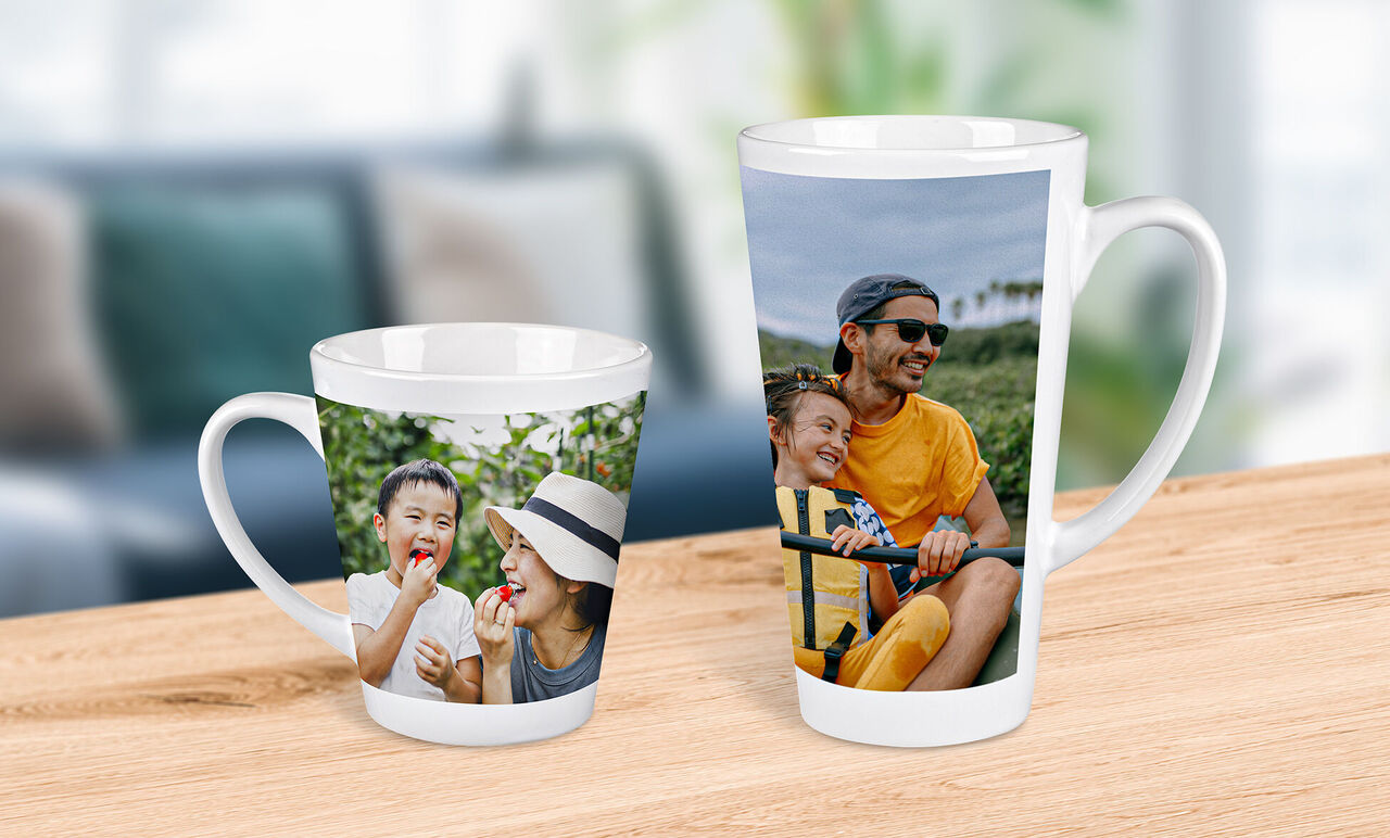 Dos tazas con fotos personales, una grande y una pequeña, sobre una mesa de madera.