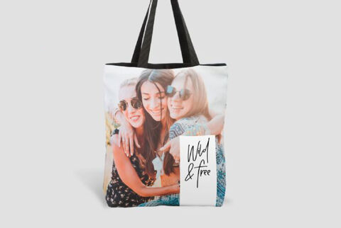 Una bolsa personalizada con la impresión 'Wild & Free' y fotos de dos amigas alegres riendo juntas.