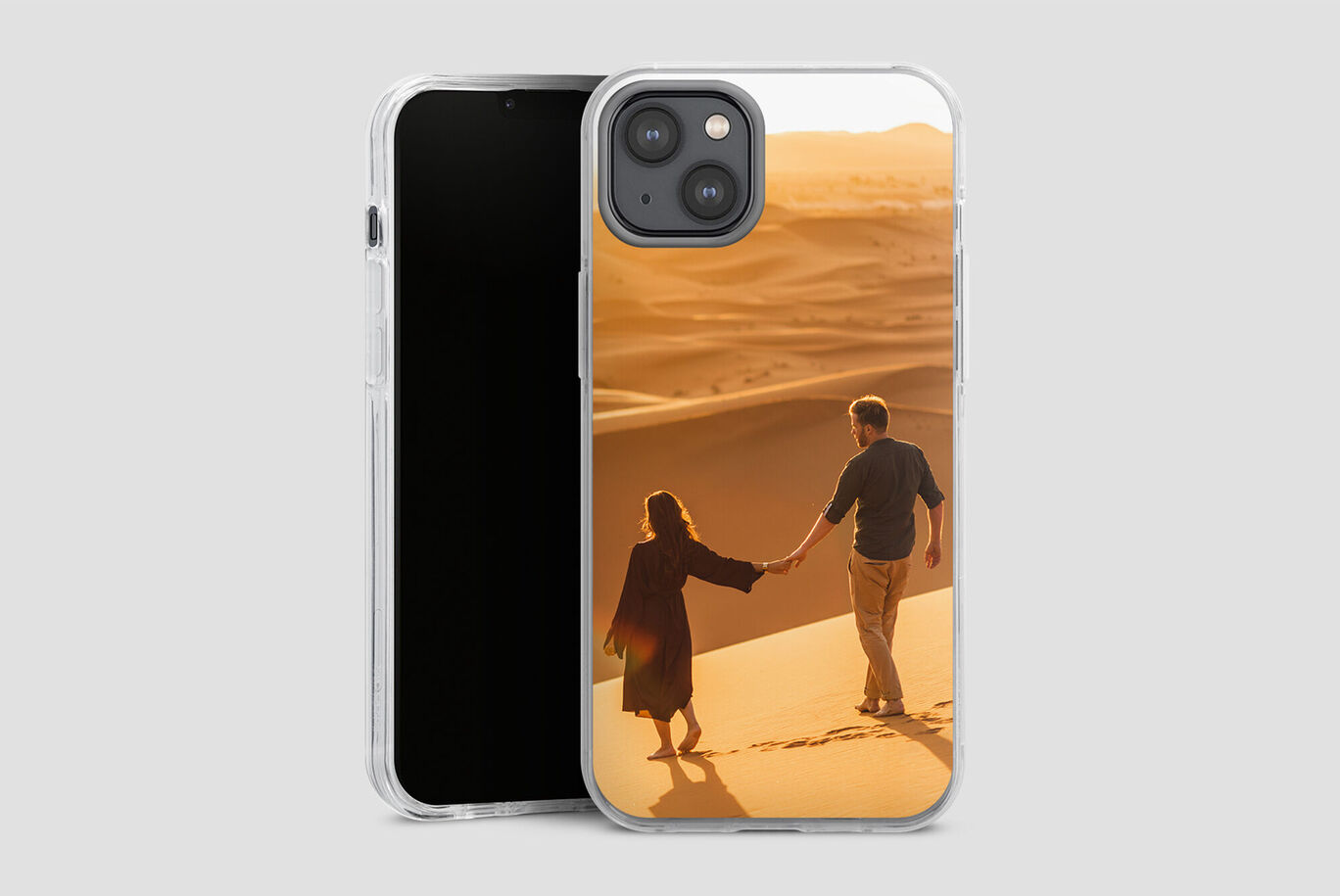 Una pareja camina de la mano sobre suaves dunas de arena.