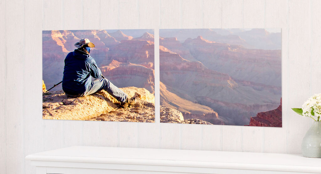 Una persona sentada en una roca en el Gran Cañón disfrutando la vista. Los colores son cálidos y el paisaje, majestuoso.