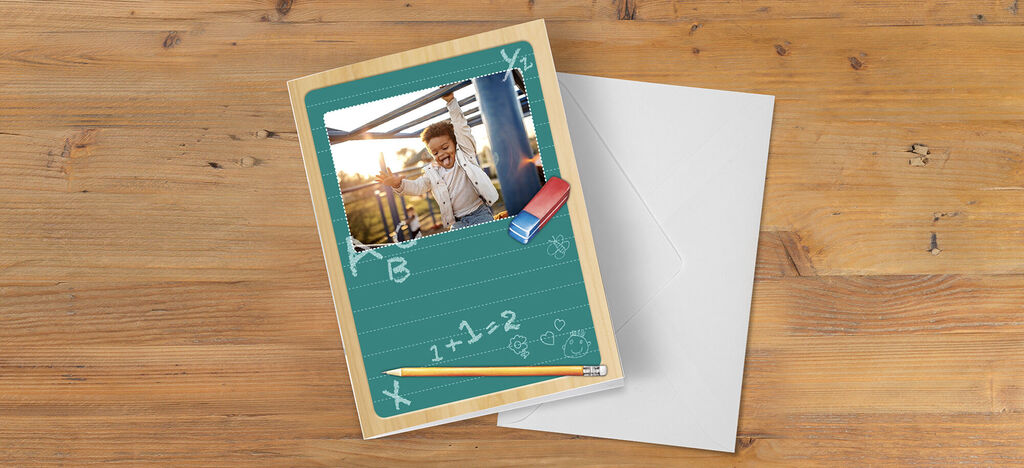 Una tarjeta de saludo con un foto de un niño alegre en una pizarra verde.
