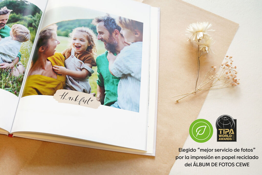 Hermoso álbum de fotos con la inscripción 'Agradecido' en una página abierta, rodeado de decoración natural.