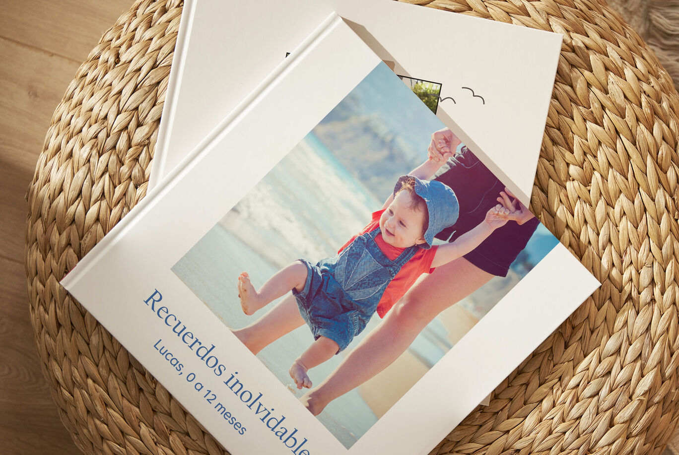 Un niño sonriente en overol azul y sombrero, sostenido por un adulto mientras juega en la playa