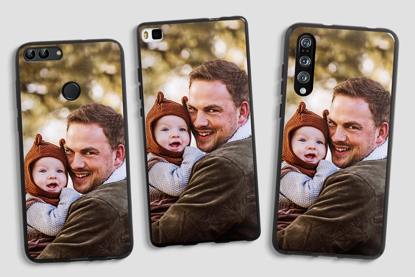 Un hombre sostiene a un niño en sus brazos, ambos sonríen y disfrutan del momento al aire libre