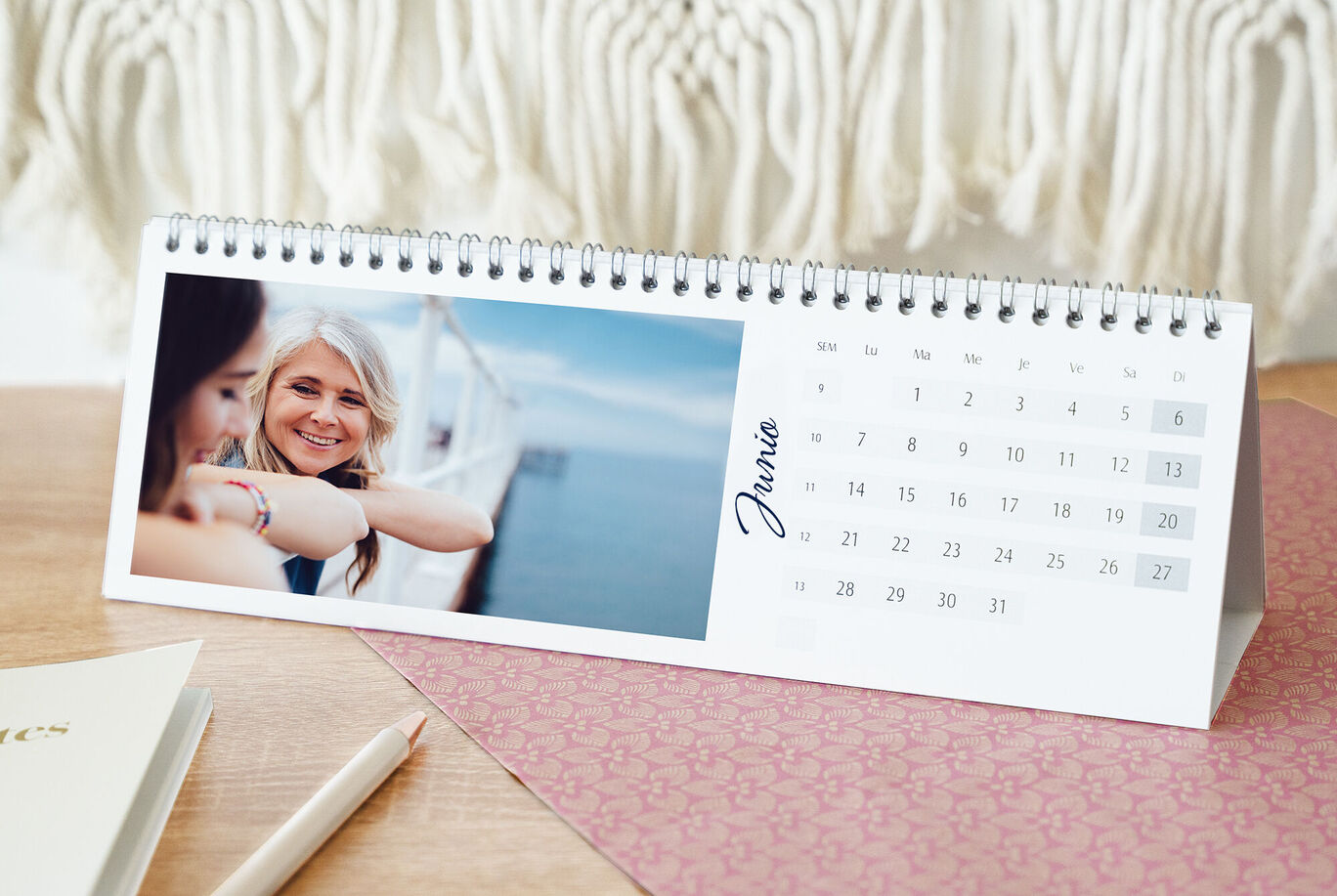 Una hermosa mesa con un calendario que muestra una escena cariñosa. El calendario tiene una vista mensual.