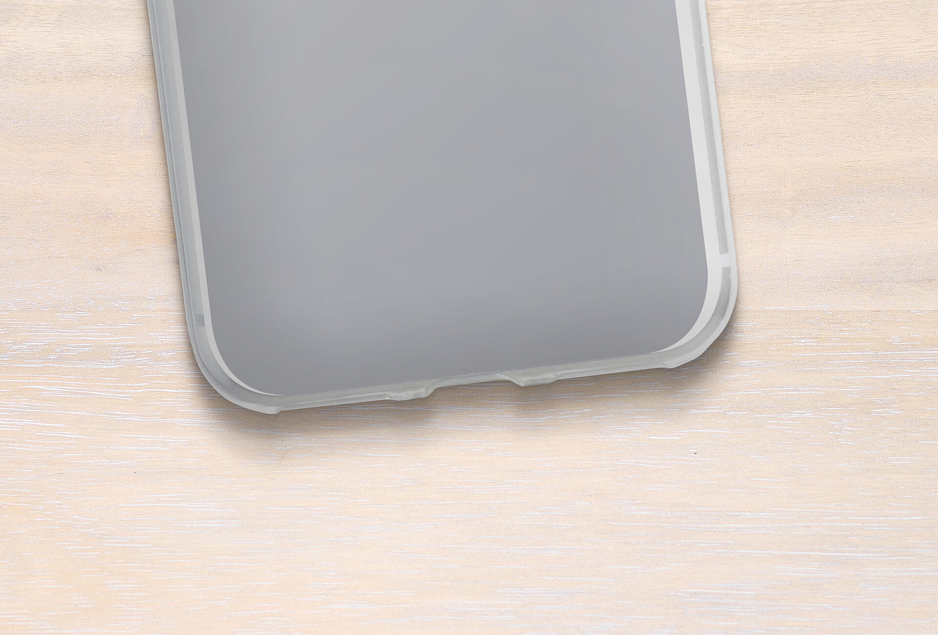 Vista de la esquina de un smartphone sobre una clara superficie de madera