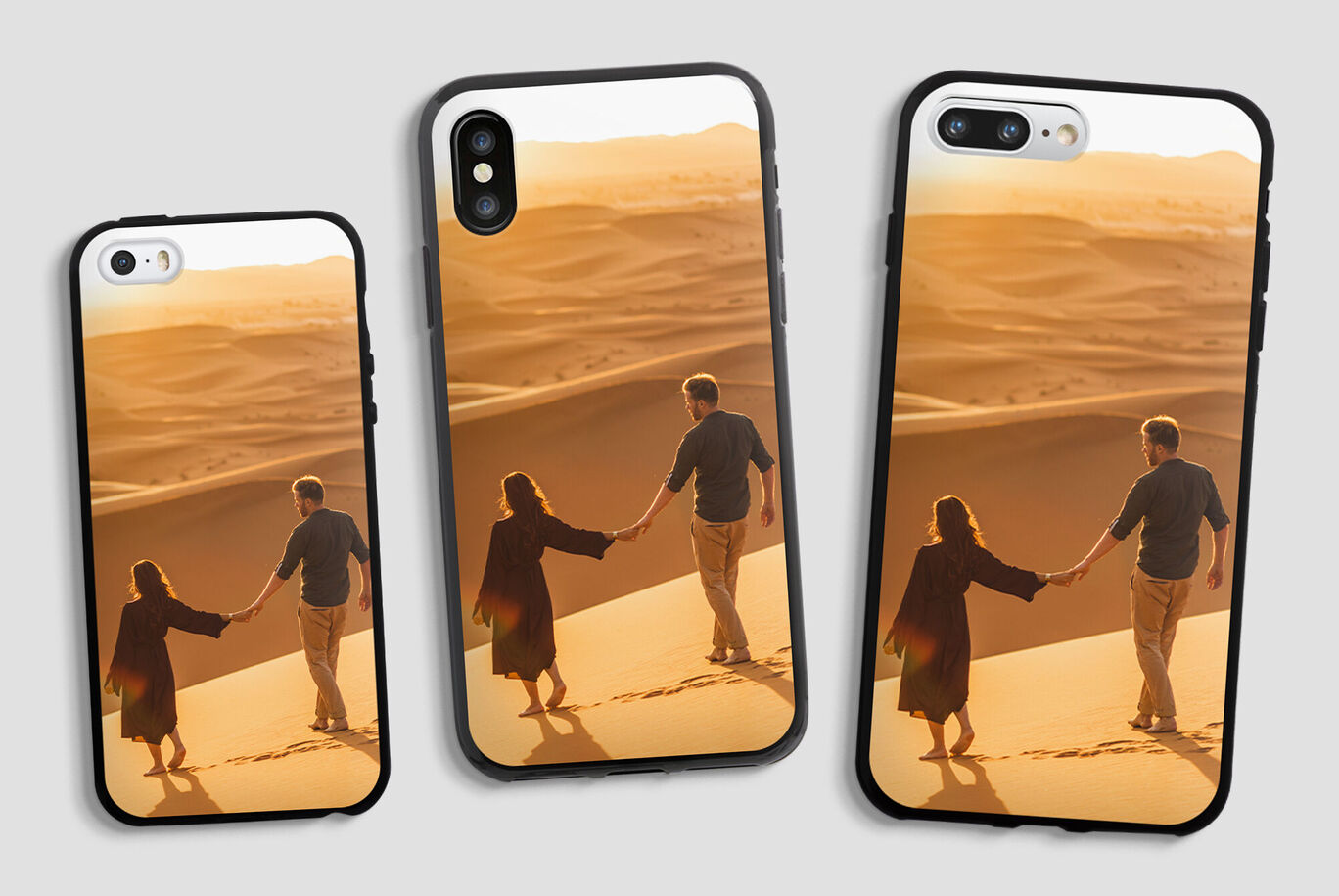 Dos personas se toman de la mano en una duna de arena al atardecer, rodeados de un desierto dorado