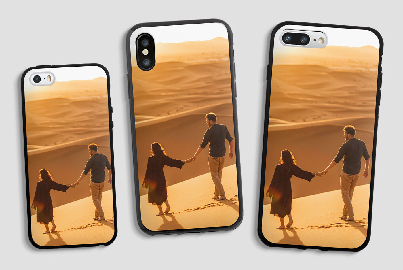 Dos personas se toman de la mano en una duna de arena al atardecer, rodeados de un desierto dorado