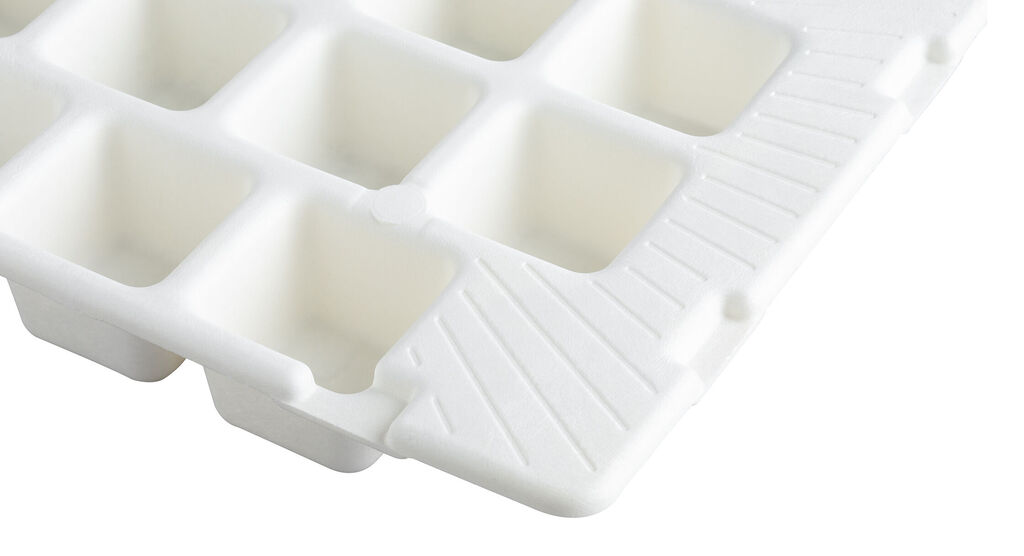 Primer plano de un molde de cubitos de hielo blanco con hendiduras redondas