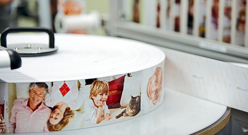 Lomo de álbumes CEWE apilados con imágenes de familia y amigos